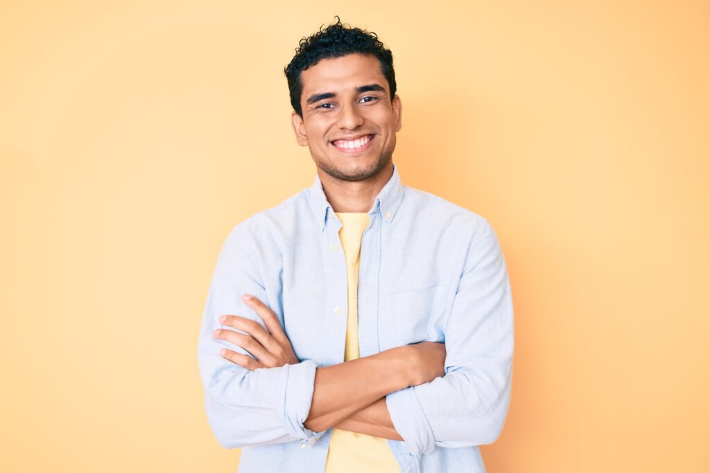 Smiling Hispanic man on yellow background