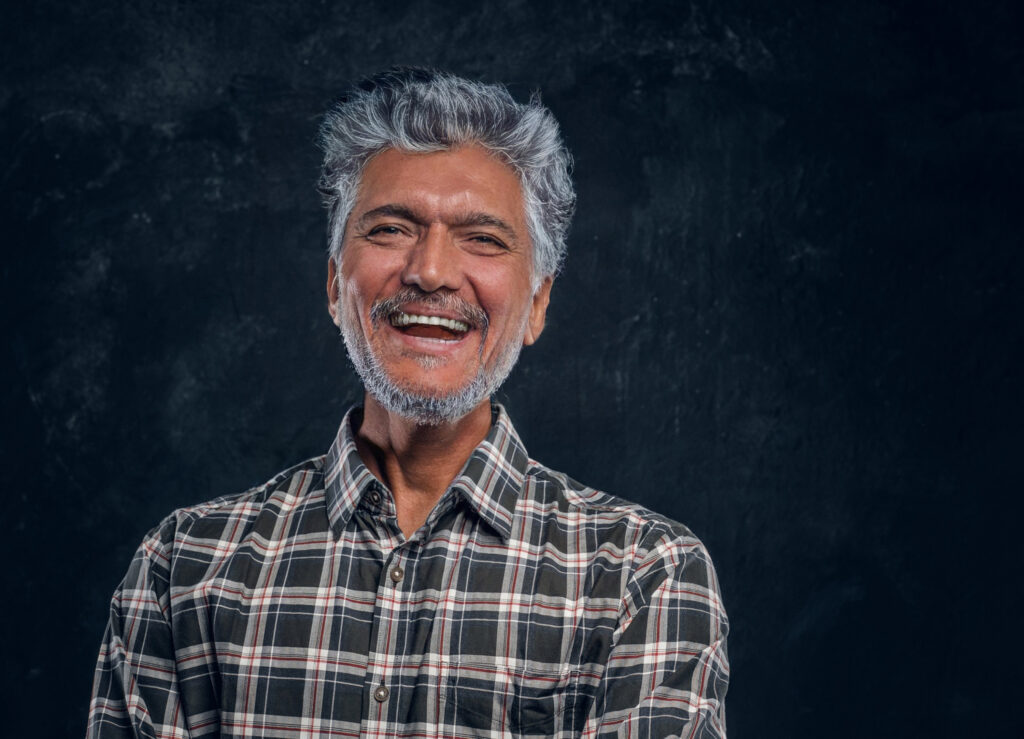 Old man smiling on dark background